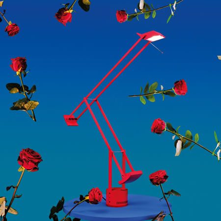 Rote Artemide Tolomeo Tischleuchte vor blauem Hintergrund mit schwebenden roten Rosen – künstlerische Inszenierung des italienischen Designklassikers