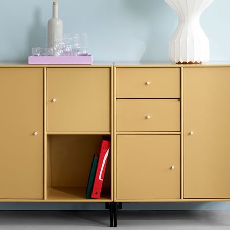 Montana Sideboard in warmem Gelbton mit offenem Fach und Schubladen, kombiniert mit Gläsern und moderner Tischleuchte – vielseitiges Stauraummöbel im nordischen Stil