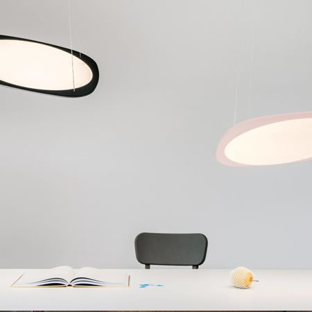 Tobias Grau Flying Pendelleuchten in Schwarz und Rosé über weißem Tisch mit minimalistischem Arbeitsplatz – modernes Lichtdesign mit sanfter, flächiger Ausleuchtung