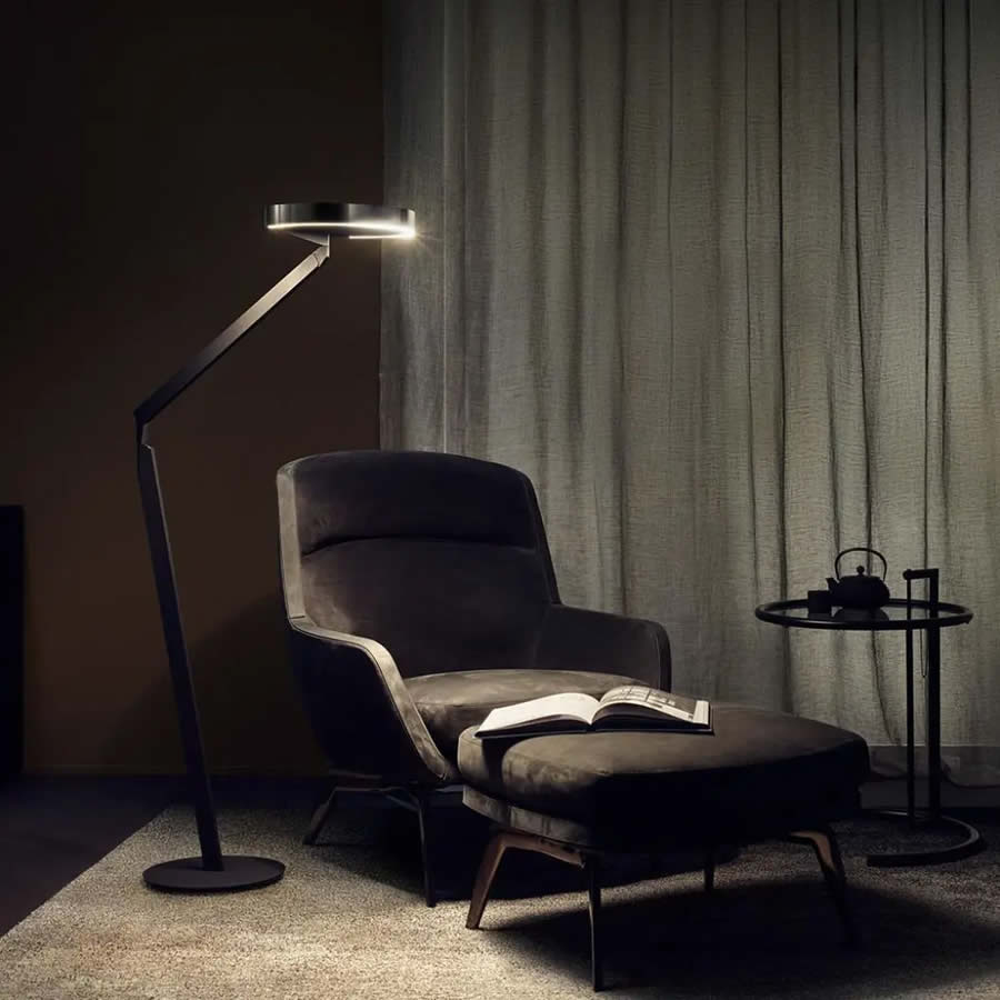 Occhio Stehlampe Gioia lettura neben Sessel in sonst dunklen Wohnzimmer