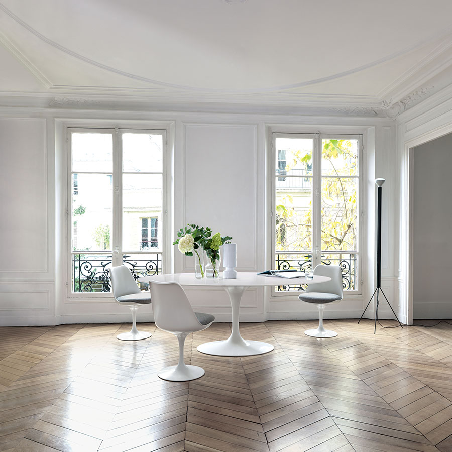 Helles Wohnzimmer mit Knoll Tisch und weißen Tulpenstühlen auf Fischgrätparkett – harmonische Verbindung von Eleganz und Funktionalität