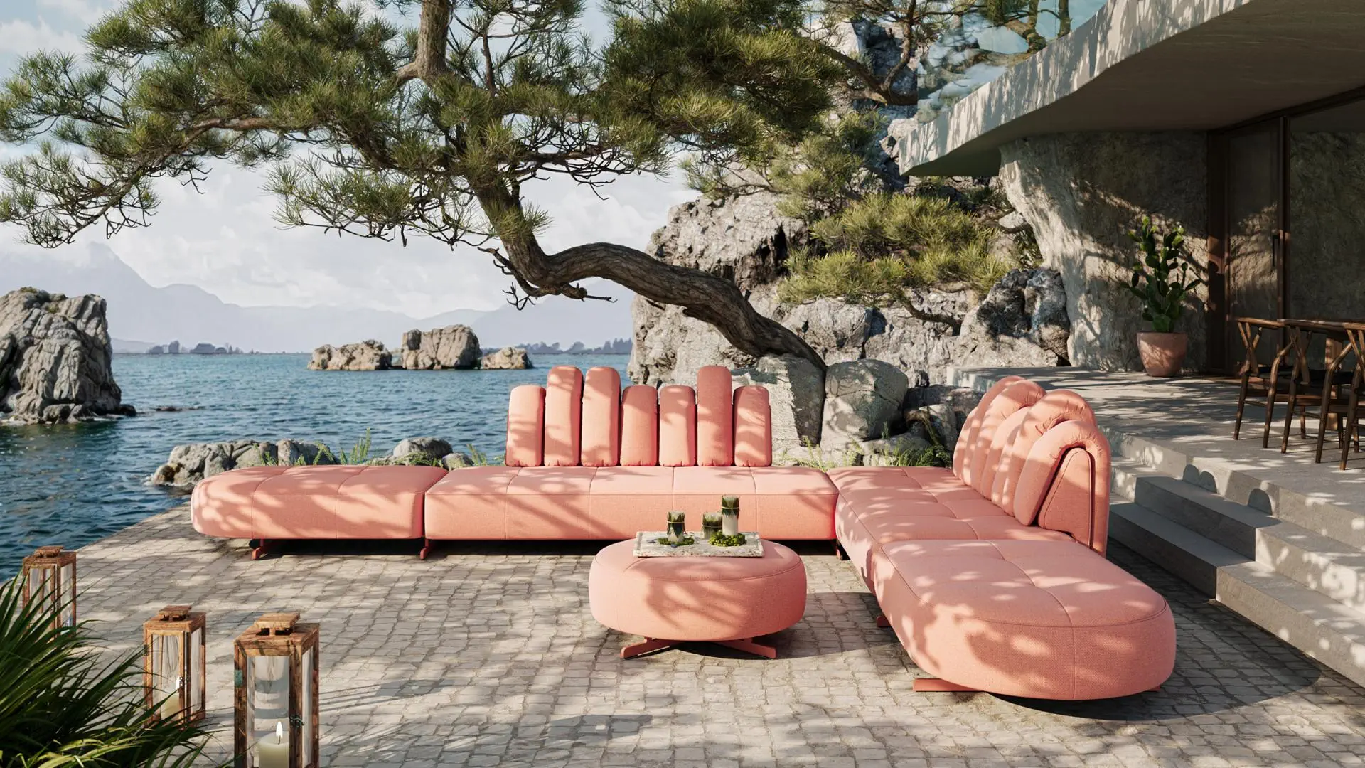 Großes rosafarbenes Outdoor-Sofa von de Sede auf Terrasse mit Meerblick, umgeben von Naturstein und Bäumen, stilvoller Rückzugsort mit modernem Design